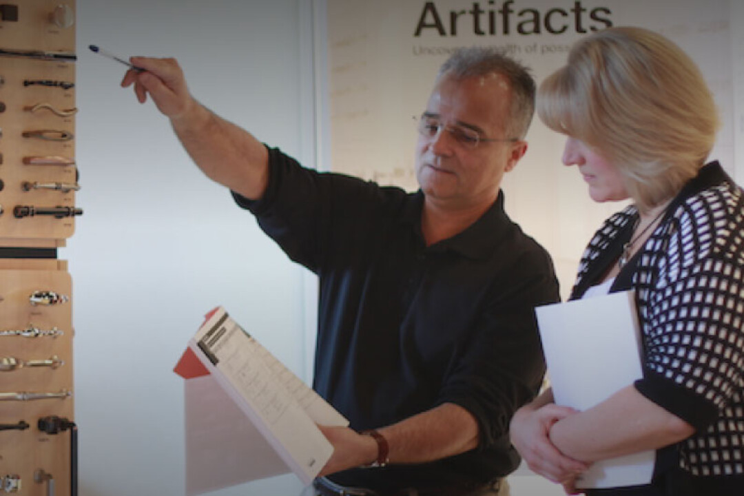 Man working in a showroom and helping a woman find a handle for her bathroom.