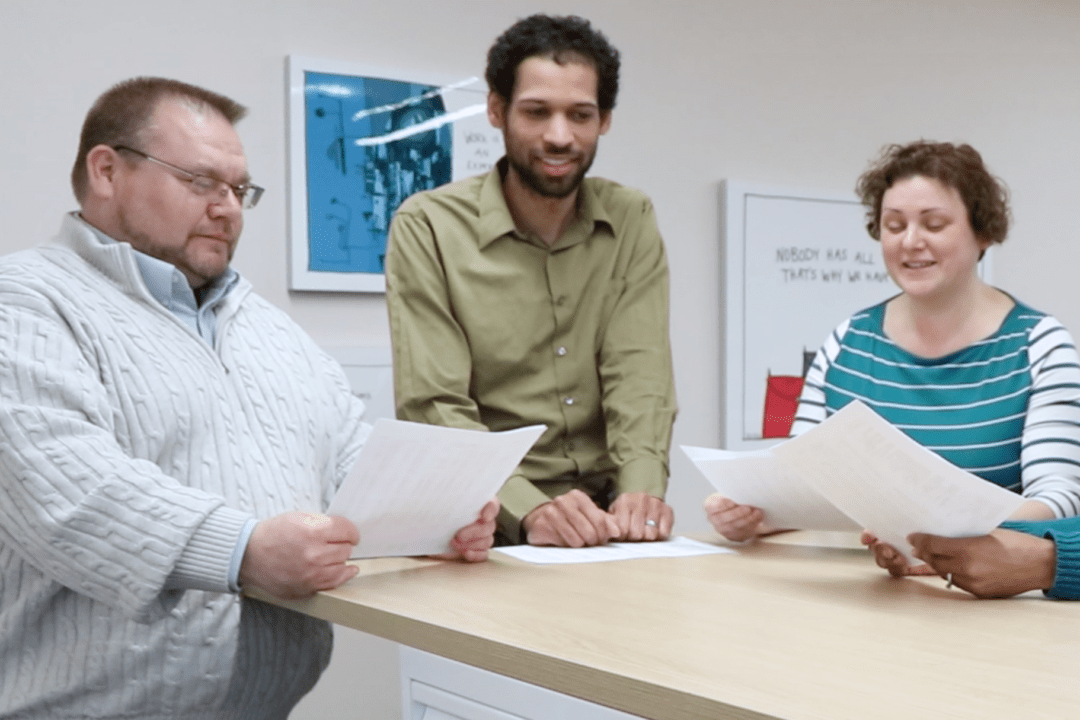 Three Hajoca employees standing at a table reviewing documents